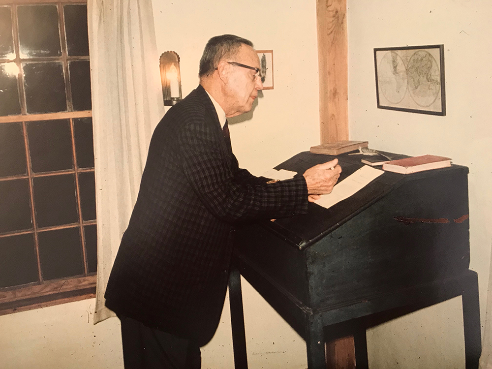 Harold Travis standing at Isaac Fiske's writing desk