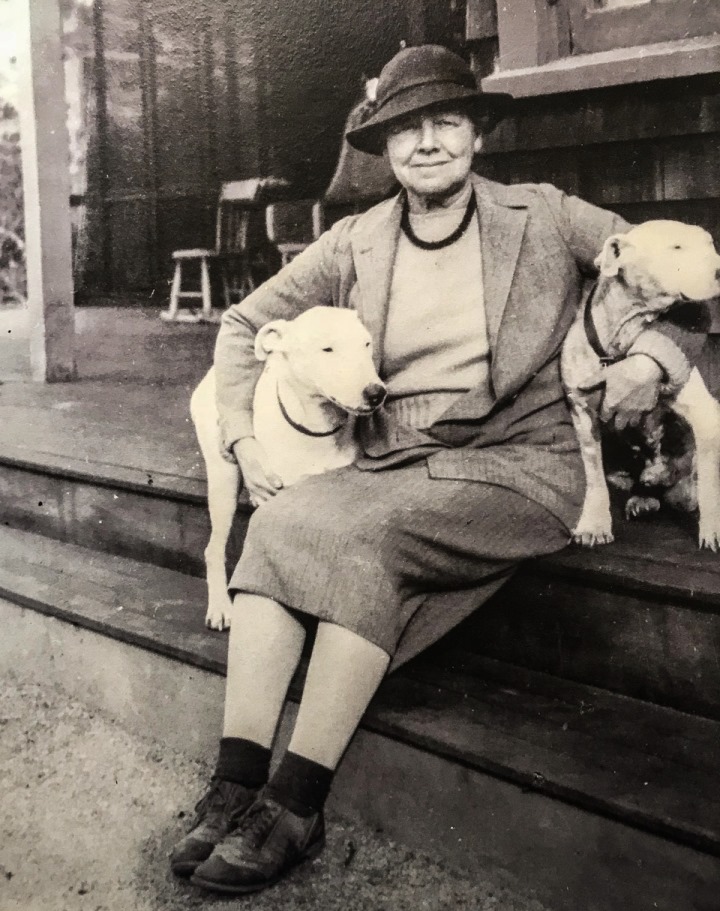 Photo of Gertrude Fiske sitting on porch with dogs